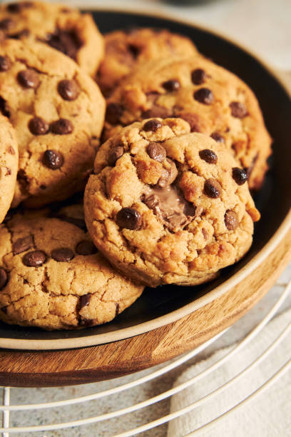 istock Plate with deliciously baked cookies with chocolate chips on a baking grid 1464961614