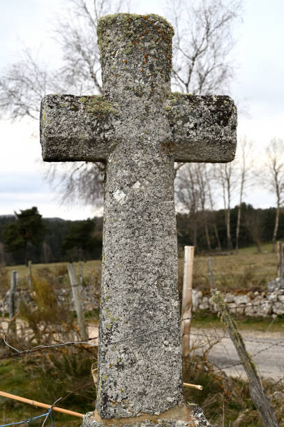 istock Granite stone christian cross in a green field 1464967267