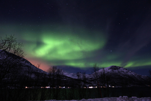 A miraculous view of green aurora lights above mountains - perfect for wallpapers