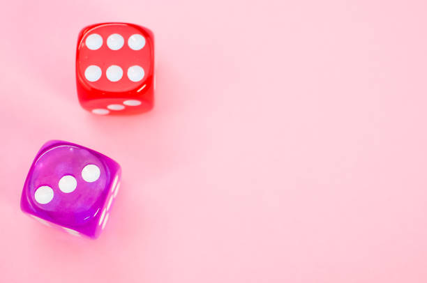 Two purple and red dices isolated on pink background