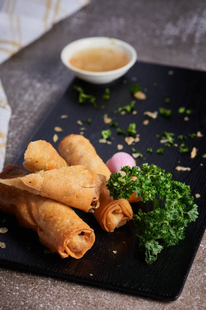 istock Vertical shot of a fried dish with salad on a black plate 1464971355