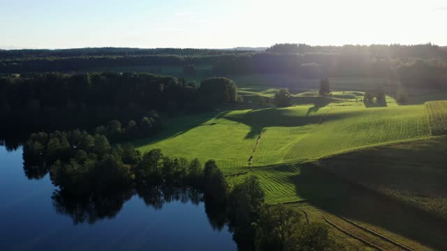Drone flight over Bavarian meadows and lake landscape