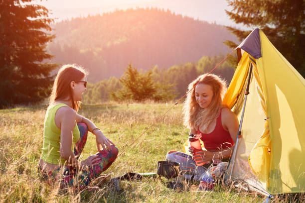 istock Two, young women sitting in campsite, having break. 1464971830