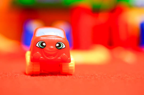 Plastic colorful toy car on red carpet