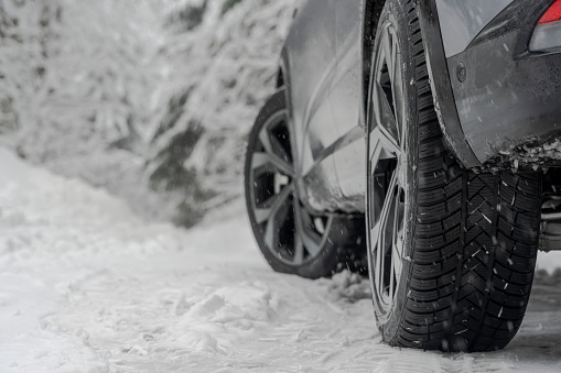 Close up shot of a car winter tire on s snow