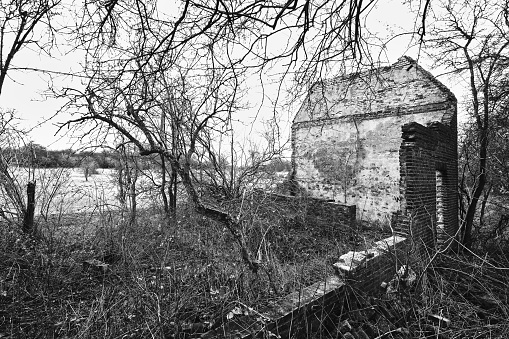 A grayscale shot of the remains of an old destroyed house