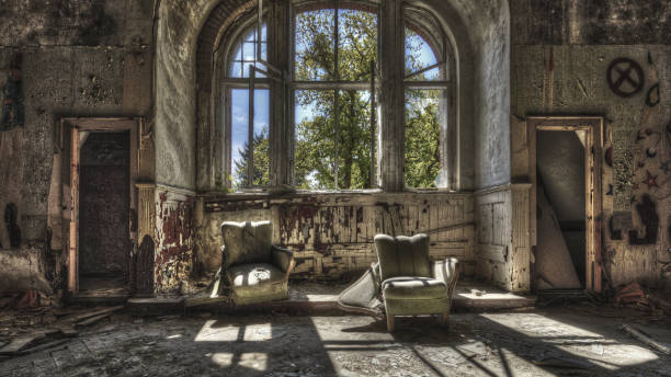 istock Damaged armchairs in an abandoned ruined room 1464977043