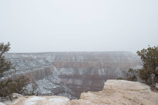 Look out over Grand Canyon rock formations in winter as snow cloud desecends