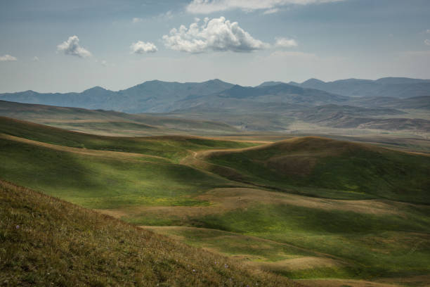 istock Mesmerizing view of green hills and mountains under a cloudy sky 1464979010