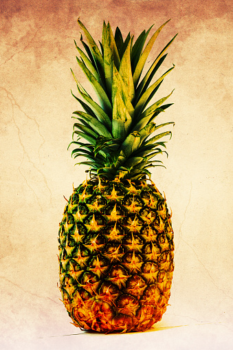 A closeup of a ripe juicy pineapple on the brown grungy background