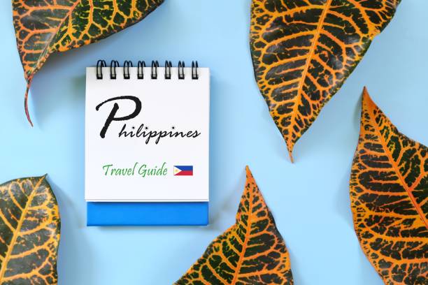 istock Philippines travel guide written on blue notepad with flag icon. Beautiful tropical flat lay composition. 1464981015
