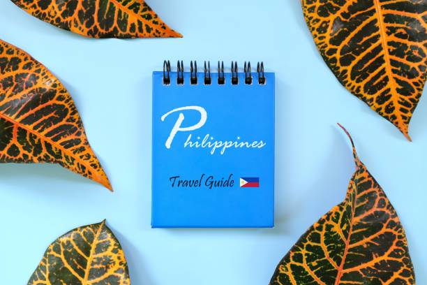 istock Philippines travel guide written on blue notepad with flag icon. Beautiful tropical flat lay composition. 1464981024