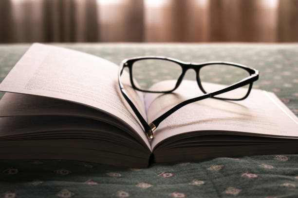 istock Closeup shot of glasses resting on a book 1464981221