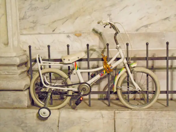 Kid’s bicycle on a white marble background at night
