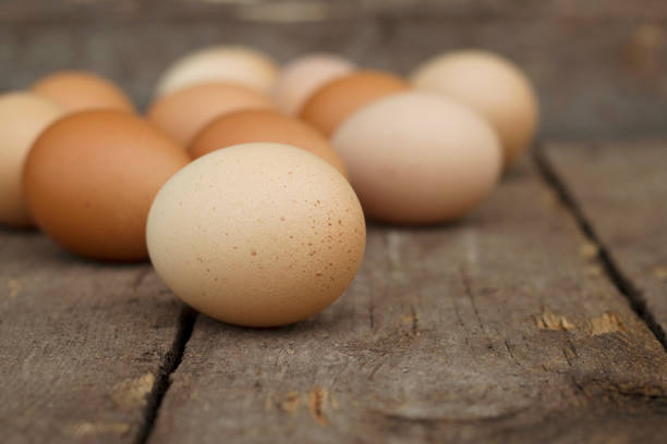 Colorful organic chicken eggs on wooden table. Natural and healthy food from village.