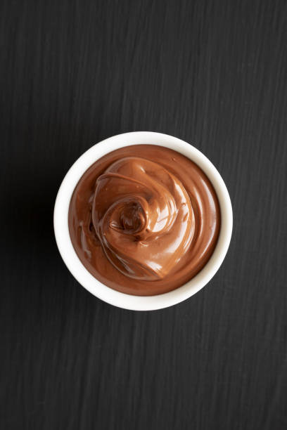 istock Homemade Chocolate Hazelnut Spread in a Bowl on a black background, top view. Flat lay, overhead, from above. 1464989979