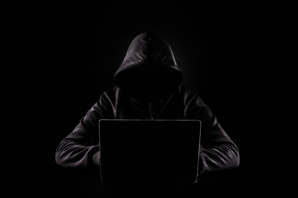 istock Cybercrime, hacking and technology crime. No face hacker with laptop on dark background. 1464991170