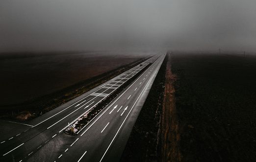 Highway road in dense fog. Aerial shot