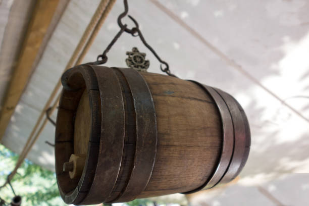 istock Old wine barrel with iron rings is suspended from a metal hook 1464992679