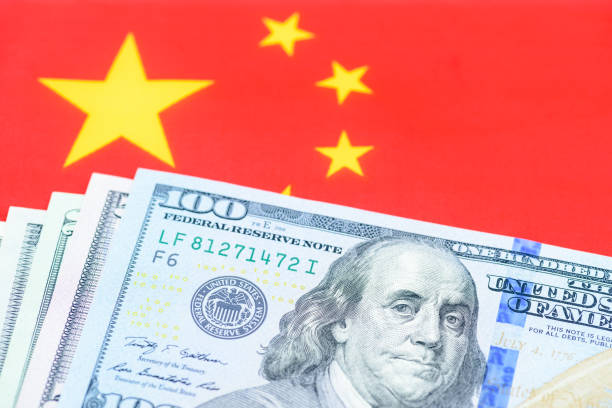 Trade tension, trade war, commercial conflict between US and China, economic concept : US dollar bill and a Chinese flag. Depicting a significant deterioration in the relationship between US and China tensión comercial, guerra comercial, conflicto comercial entre estados unidos y china, concepto económico: billete de dólar estadounidense y una bandera china. representación de un deterioro significativo en la relación entre estados unidos y china