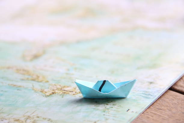istock Paper boat on Ancient world map. 1465001151