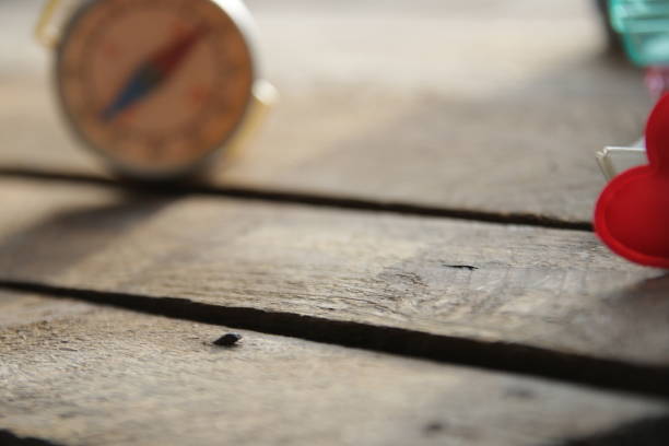 Compass is casting a shadow on a table in the sun
