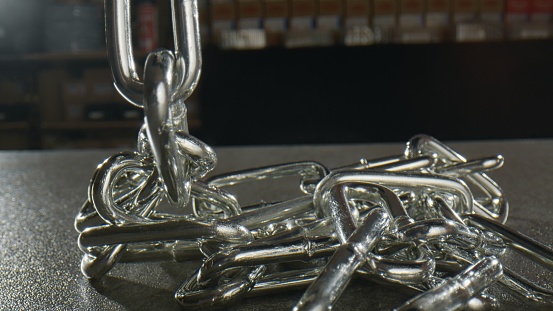 Wide metal silver chains on a black table