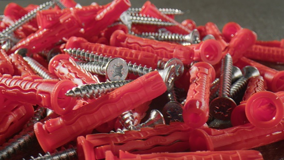 Heap of red dowels and silver shiny screws