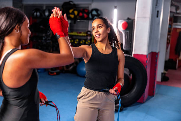 Two Hispanic Females Doing High Five While Boxing Together stock photo