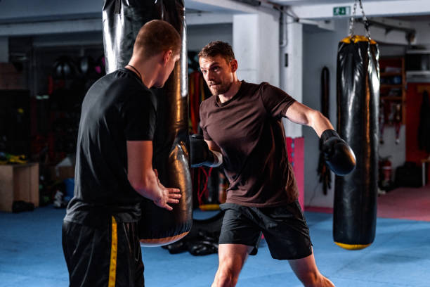 istock Handsome Male Caucasian Boxing Coach Working With A Fit Athlete 1465033596