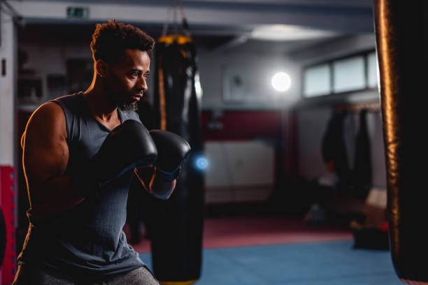 istock Focused Mid Adult Multicultural Male Hitting A Punching Bag 1465033603