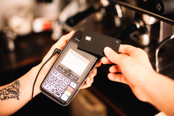 istock Barista holding credit card reader terminal while customer making contactless payment using credit card 1465034014