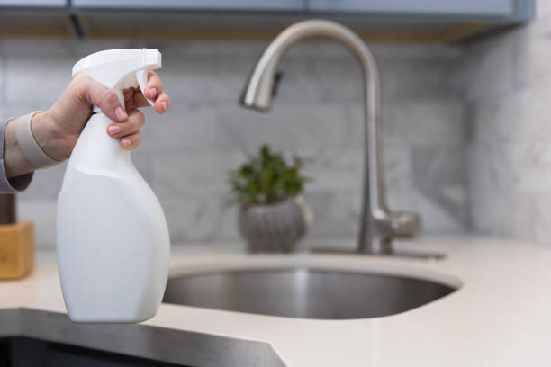 istock Woman cleaning a kitchen with a sanitizing spray 1465037434