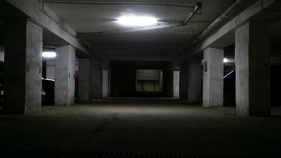 Dark spookie parking garage with electric light. Horror movie scene. Action movie scene. Spooky background with a copy space