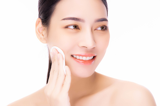 Beautiful young Asian woman cleaning face with cotton pad Beauty girl clean fresh skin on white background Cosmetology Cosmetic Face care Facial care Beauty face Beauty and Spa Asian woman portrait