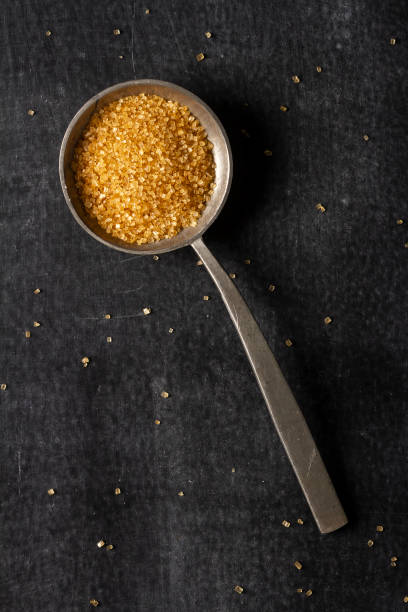 istock Big old spoon with brown sugar on black background 1465041377