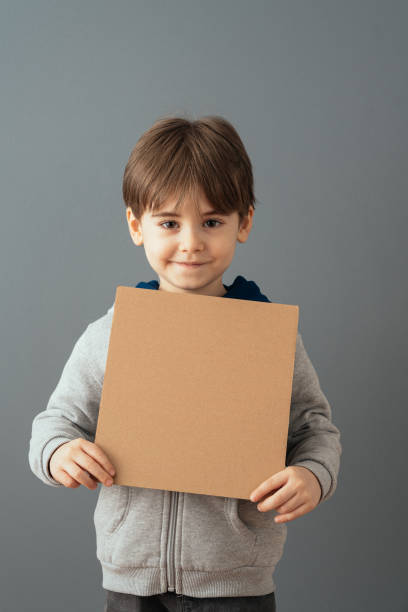 istock Little boy holding a clean cardboard sign 1465043475