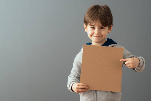 istock Little boy holding a clean cardboard sign 1465043728