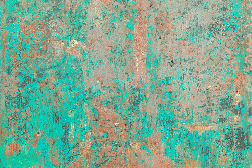 Close-up of weathered green-painted cement flooring texture that forms an abstract, rich, colorful pattern