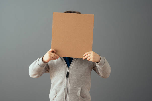 istock Little boy holding a clean cardboard sign 1465046178