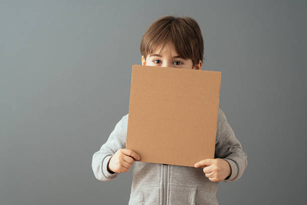 Little boy holding a clean cardboard sign