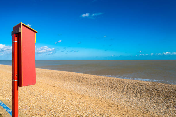 人けのない夏のビーチで見られる赤い塗装のライフリングボックスの浅い焦点。 - life jacket buoy sign sky ストックフォトと画像
