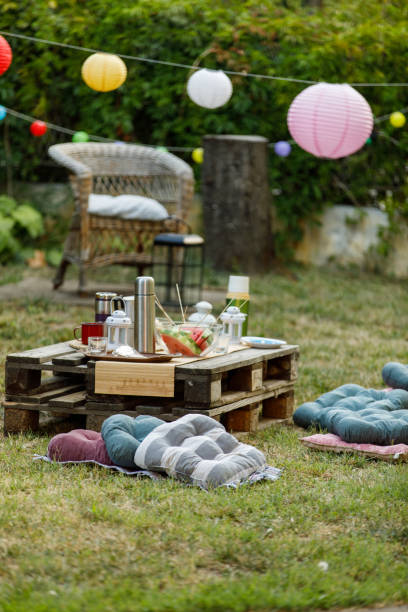 Backyard garden party setting is complete with beautiful decorations, food and drink, and outdoor seating