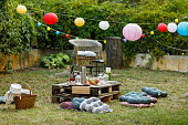 Backyard garden party setting is complete with beautiful decorations, food and drink, and outdoor seating