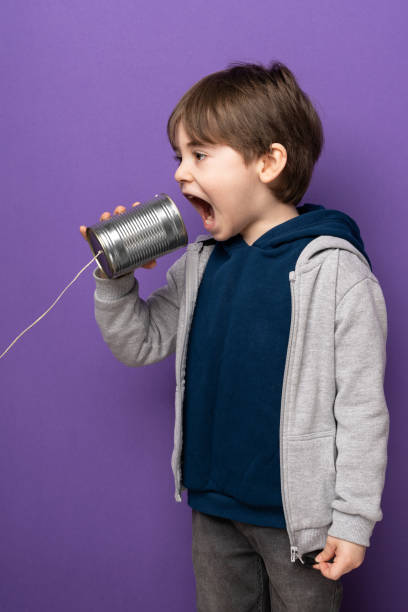 istock Little boy using a tin can as telephone 1465056826