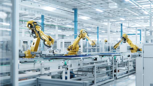 large production line with industrial robot arms at modern bright factory. solar panels are being assembled on conveyor. automated manufacturing facility - autonom teknik fotografier bildbanksfoton och bilder