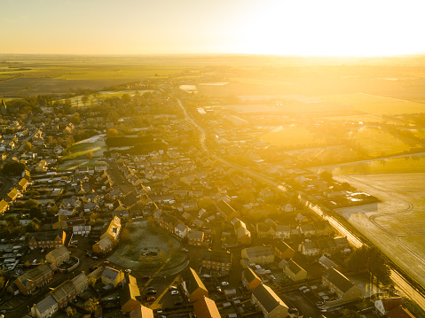 Drone view of a typical English town as seen during evening sunlight. The town has expanded with recent housing developments.