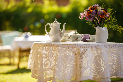 Charming table setting with a vintage tea pot and flowers.