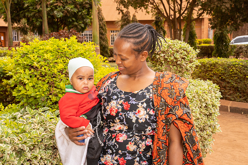 Karatu, Tanzania - October 16th, 2022: A mother smiling to her baby in the Karatu, Tanzania, churchyard.