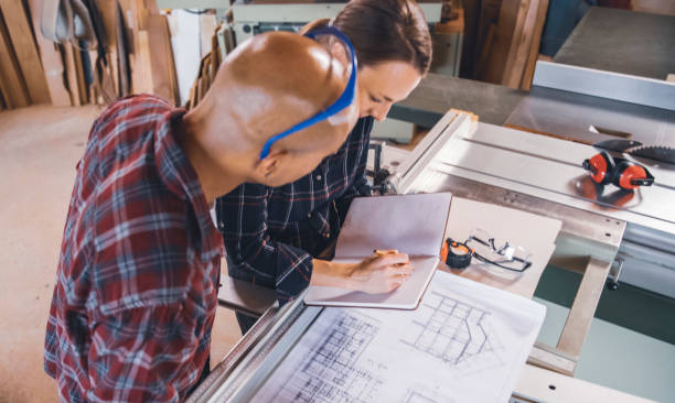 istock Male and Female Carpenters  Looking at Blueprints 1465064521